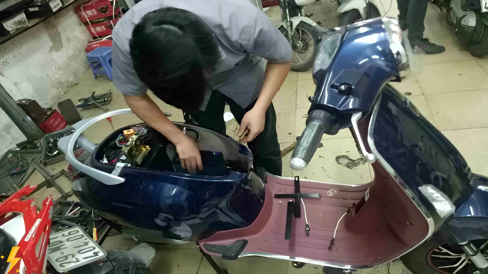 nhân viên đang sửa xe máy điện 